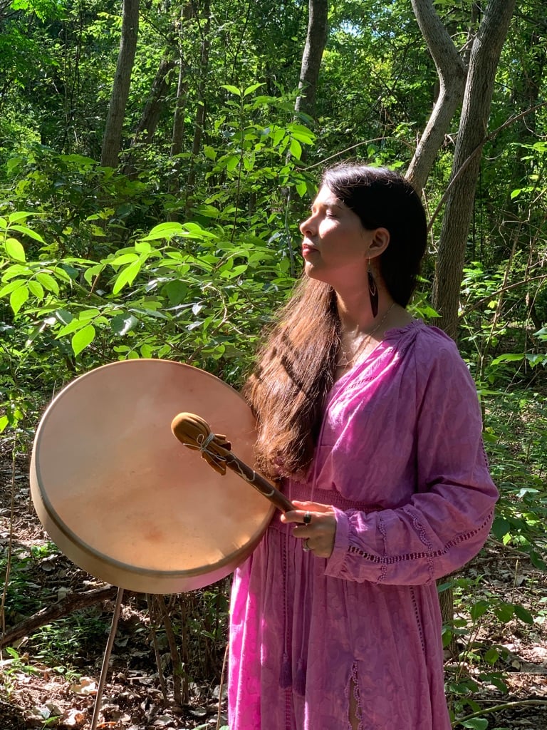 Laura Maesaka with her ceremonial drum in the forest