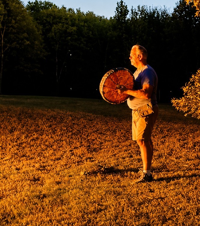Randy drumming alone in an open field at golden hour